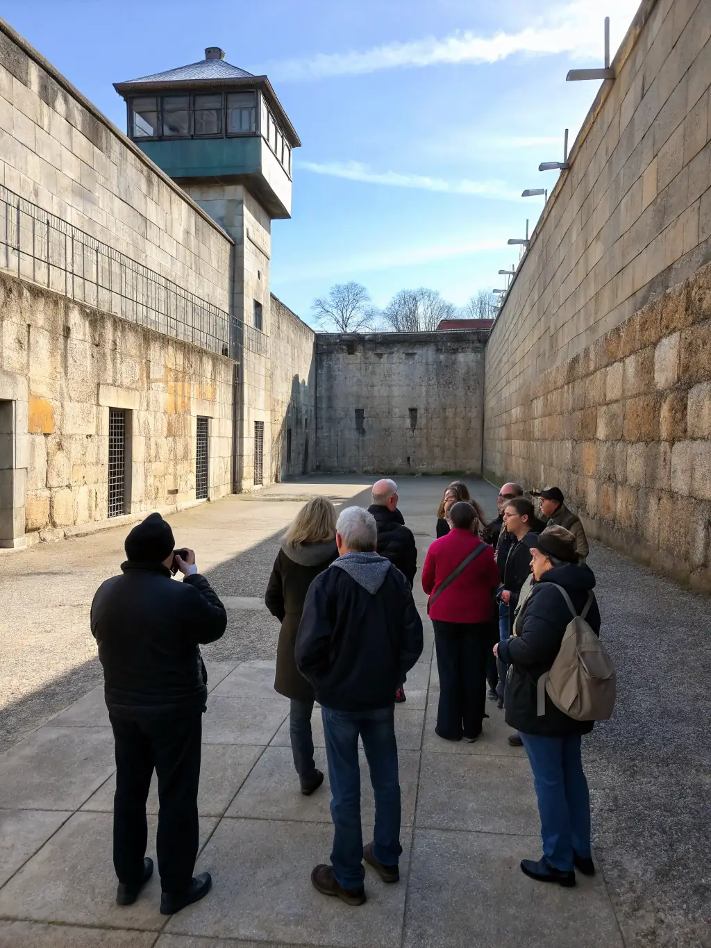 A photograph showcasing a guided tour of the Saint Geraud Abbey ruins, with a knowledgeable guide explaining the historical context to a group of attentive visitors.